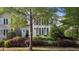 Charming two-story home featuring arched windows, shutters, and lush landscaping at 1703 Happiness Hill Ln, Raleigh, NC 27614