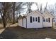 Tan house with black shutters, surrounded by trees and landscaping at 1723 Oklahoma Ave, Burlington, NC 27217