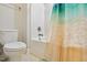 Bright bathroom featuring toilet and a clean shower-tub with a decorative shower curtain at 1726 Rapids Ct, Franklinton, NC 27525