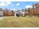 Two-story house with a gray roof and beige siding, a large yard with mature trees and a driveway at 1726 Rapids Ct, Franklinton, NC 27525