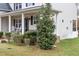 Front porch with rocking chairs, landscaping, and a holly bush at 1726 Rapids Ct, Franklinton, NC 27525