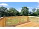 Wooden back deck overlooking lawn with trees, a tranquil outdoor space for relaxation and entertainment at 173 Grove Township Way, Angier, NC 27501