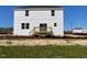 Backyard view of a two-story home with a wooden deck and construction in the background at 173 Grove Township Way, Angier, NC 27501
