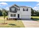 Charming two-story home with a well-manicured lawn, black shutters and a spacious two-car garage at 173 Grove Township Way, Angier, NC 27501