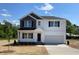 Charming two-story home with black and white accents, a two car garage and manicured landscaping at 173 Grove Township Way, Angier, NC 27501