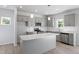 Bright kitchen featuring gray cabinets, a center island, stainless steel appliances, and subway tile backsplash at 173 Grove Township Way, Angier, NC 27501