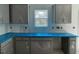 Unfinished kitchen with gray cabinets and a window offering natural light at 173 Grove Township Way, Angier, NC 27501