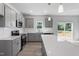 Stylish kitchen featuring gray cabinets, quartz countertops, subway tile backsplash, and stainless steel appliances at 173 Grove Township Way, Angier, NC 27501