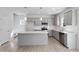 Modern kitchen with gray cabinets, stainless steel appliances, a center island, and light-colored wood flooring at 173 Grove Township Way, Angier, NC 27501