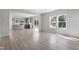 Open-concept living area with wood floors, big windows, and seamless transition to the modern kitchen at 173 Grove Township Way, Angier, NC 27501
