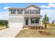 Two-story home showcasing classic siding, an attached garage, and a well-manicured lawn at 178 Grove Township Way, Angier, NC 27501