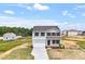 Two-story home with white siding, black shutters, attached garage, concrete driveway and landscaping at 178 Grove Township Way, Angier, NC 27501