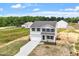 New two-story home featuring white siding, black shutters, attached garage, concrete driveway, and landscaping at 178 Grove Township Way, Angier, NC 27501