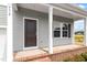 Inviting front porch showcasing gray siding, white columns, and a dark front door at 178 Grove Township Way, Angier, NC 27501