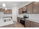 Modern kitchen features stainless steel appliances, brown cabinets, white subway tile backsplash, and an island at 178 Grove Township Way, Angier, NC 27501