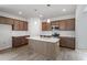 Open kitchen featuring wood-style floors, brown cabinets, white subway tiles, and an island at 178 Grove Township Way, Angier, NC 27501