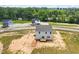 Back of new two-story home with a wood deck, light siding, and dark roof at 178 Grove Township Way, Angier, NC 27501