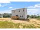 Rear exterior of new two-story home with a wooden deck, sliding glass door, light siding, and dark roof at 178 Grove Township Way, Angier, NC 27501
