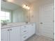 Bathroom featuring double sink vanity with white cabinets, brushed gold hardware, and grey tile flooring at 1813 Bright Lantern Way, Wendell, NC 27591