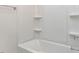 This bathroom features a white tub with tiled walls and built-in shelves at 1813 Bright Lantern Way, Wendell, NC 27591