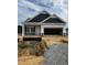 New construction featuring a two-car garage and covered front entry awaiting landscaping at 19 E American Marigold Dr # 34, Benson, NC 27504