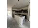 Spacious kitchen with cabinets and center island wrapped in plastic during construction phase at 19 E American Marigold Dr # 34, Benson, NC 27504