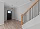 Bright entryway with hardwood floors, black door, and staircase at 20 Wes Sandling Rd, Franklinton, NC 27525