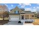 Two-story house with a stone and shingle exterior, front porch, and a two-car garage at 20 Wes Sandling Rd, Franklinton, NC 27525