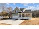 Two-story house with a stone and shingle exterior, front porch, and a two-car garage at 20 Wes Sandling Rd, Franklinton, NC 27525