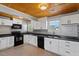 Modern kitchen with white cabinets, black appliances and tin backsplash at 2041 Grassy Creek Virgilina Rd, Oxford, NC 27565