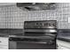 Black electric range with modern controls and overhead vent at 2041 Grassy Creek Virgilina Rd, Oxford, NC 27565