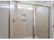 Modern bathroom with beige tile, glass shower door, and natural light at 211 Grove Township Way, Angier, NC 27501