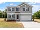 Charming two-story home with gray siding, black shutters, and a two-car garage at 211 Grove Township Way, Angier, NC 27501