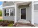 Close-up of front door with brick steps and gray siding with white trim at 211 Grove Township Way, Angier, NC 27501