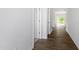 Hallway with white walls and wood-look flooring leading into a brightly lit room at 211 Grove Township Way, Angier, NC 27501