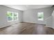 Bright living room featuring wood-look flooring, staircase, and ample windows for natural light at 211 Grove Township Way, Angier, NC 27501
