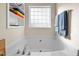 Relaxing bathroom featuring a large garden tub and window at 2118 Stoney Spring Dr, Raleigh, NC 27610