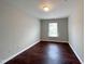 Bright bedroom with dark wood floors and a window at 2221 Valley Edge Dr # 105, Raleigh, NC 27614
