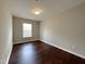 Simple bedroom with dark wood floors and a window at 2221 Valley Edge Dr # 105, Raleigh, NC 27614