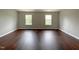 Spacious bedroom with dark wood flooring and two windows at 2221 Valley Edge Dr # 105, Raleigh, NC 27614