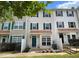 Tan three-story townhouse with teal front door and white fence at 2221 Valley Edge Dr # 105, Raleigh, NC 27614