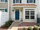 Front entry of a townhouse with a teal door and brick walkway at 2221 Valley Edge Dr # 105, Raleigh, NC 27614