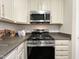 Modern kitchen with stainless steel appliances and white cabinets at 2221 Valley Edge Dr # 105, Raleigh, NC 27614