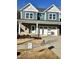 Two-story house with teal siding, brick accents, and a two-car garage at 229 Beacon Dr, Pittsboro, NC 27312