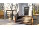 Modern home entrance with dark door, wooden stairs, and landscaping at 2513 Rochelle St, Durham, NC 27703