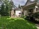 Lush backyard with a stone fireplace, a seating area, and manicured landscaping, perfect for outdoor entertaining at 2900 Glenanneve Pl, Raleigh, NC 27608