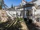 Exterior view of a backyard with a stone fireplace, a covered patio, and a well-maintained lawn at 2900 Glenanneve Pl, Raleigh, NC 27608
