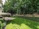 Lush backyard featuring a manicured lawn, mature trees, and privacy hedges, creating a serene outdoor space at 2900 Glenanneve Pl, Raleigh, NC 27608
