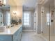 Elegant bathroom featuring a long vanity with light blue cabinets and a glass-enclosed shower at 2900 Glenanneve Pl, Raleigh, NC 27608