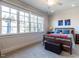 Sunlit bedroom with large windows, neutral carpet, and a comfortable bed with decorative pillows at 2900 Glenanneve Pl, Raleigh, NC 27608